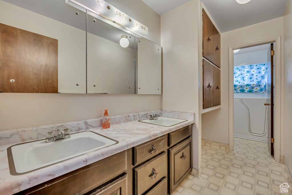 Bathroom with double vanity and tile patterned floors