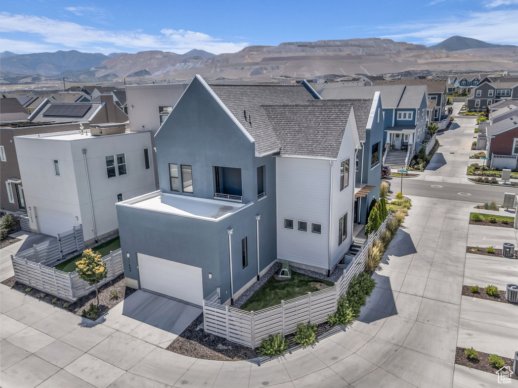 View of front of home with a mountain view, a garage, stucco siding, and a residential view