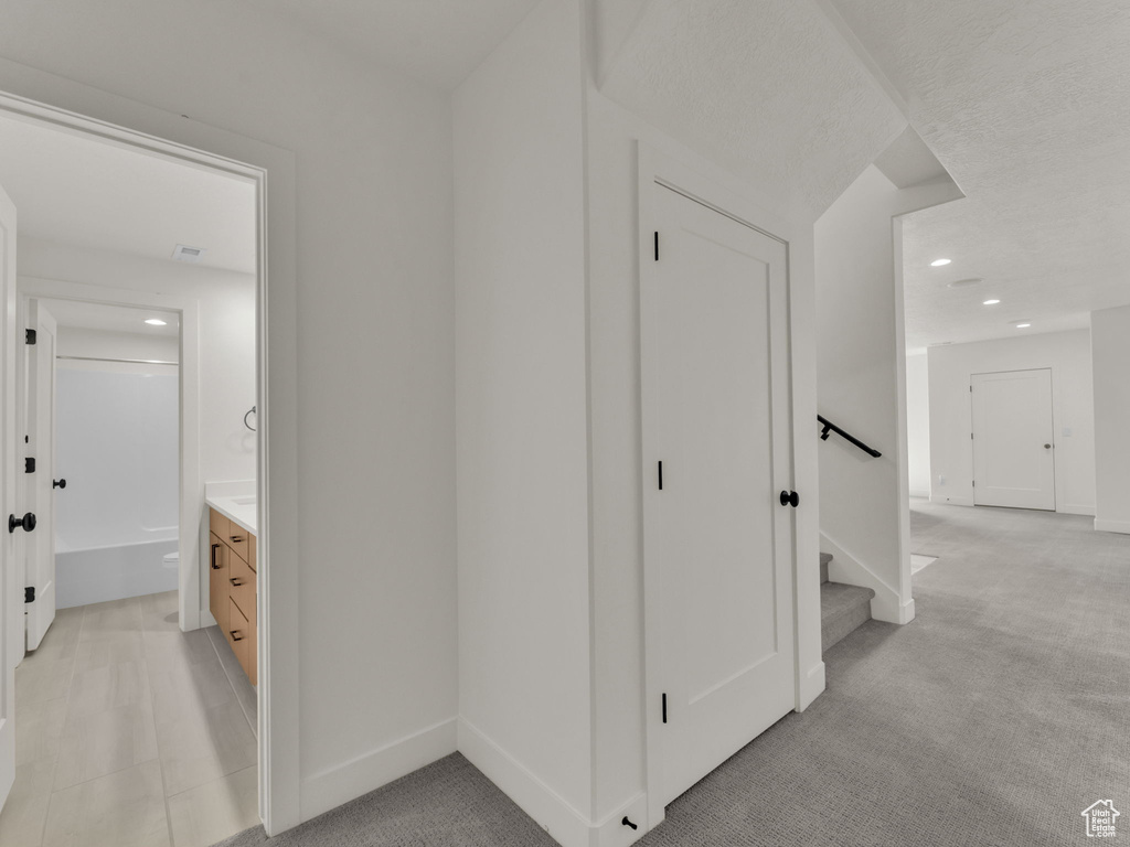 Hall with recessed lighting, light carpet, and stairway