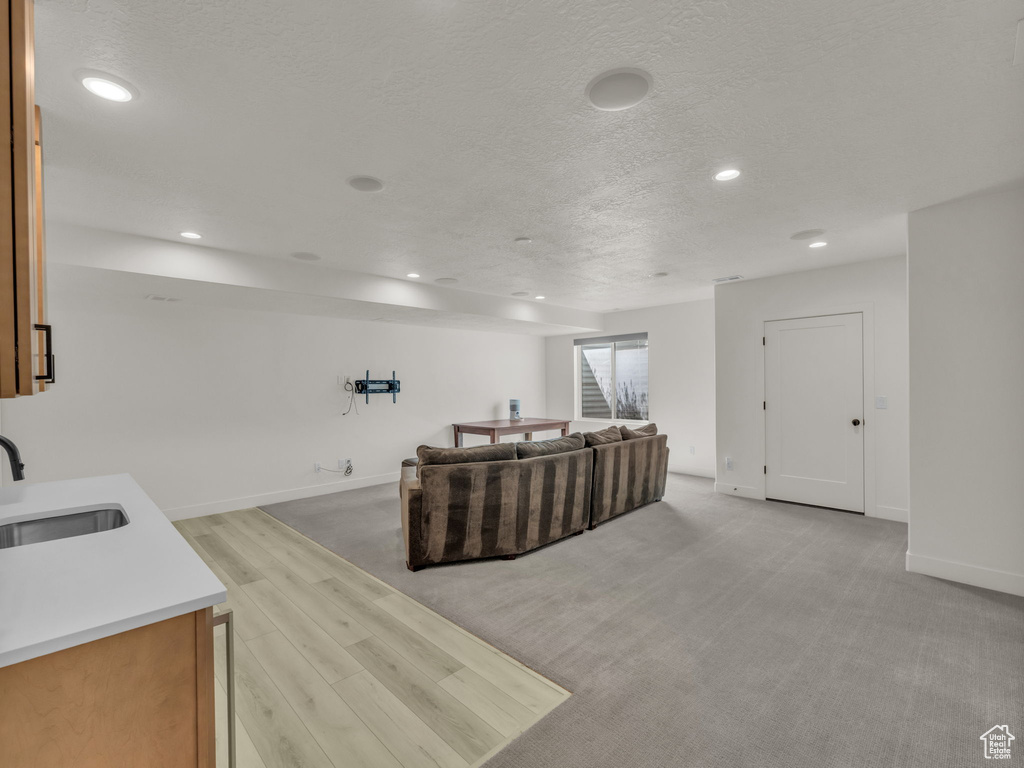 Living room featuring recessed lighting, a textured ceiling, and light wood-style floors