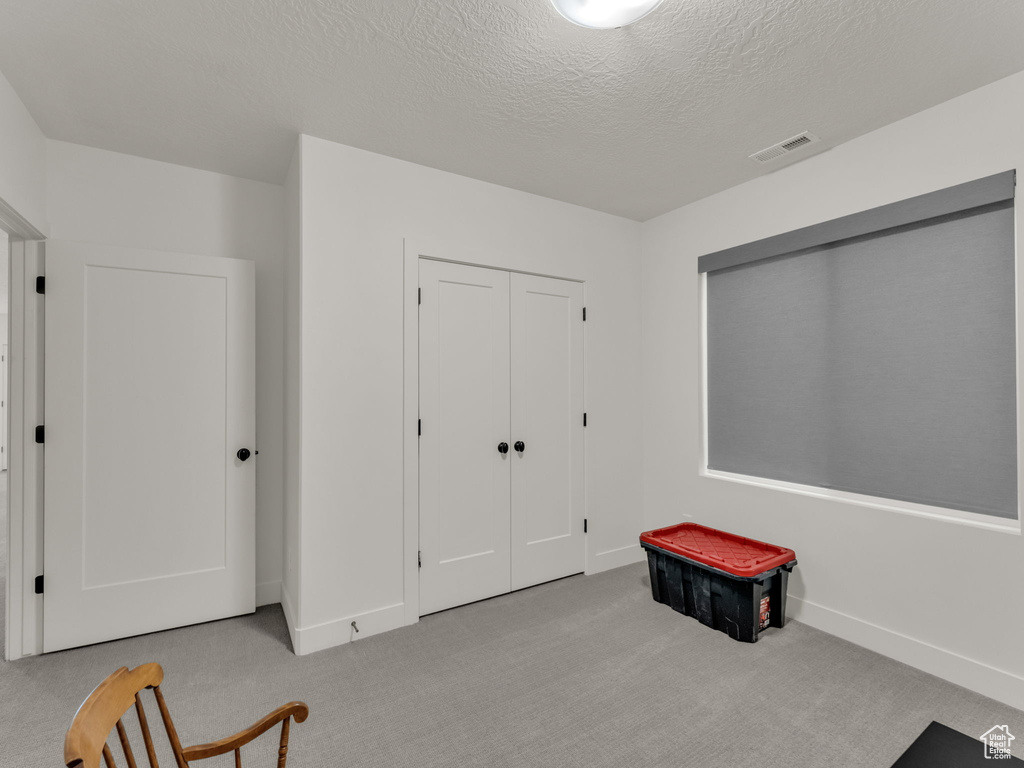 Unfurnished bedroom featuring carpet floors and a textured ceiling
