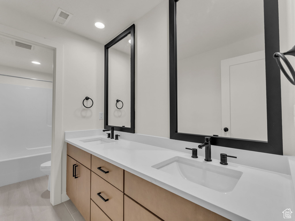 Bathroom featuring double vanity,  shower combination, and recessed lighting