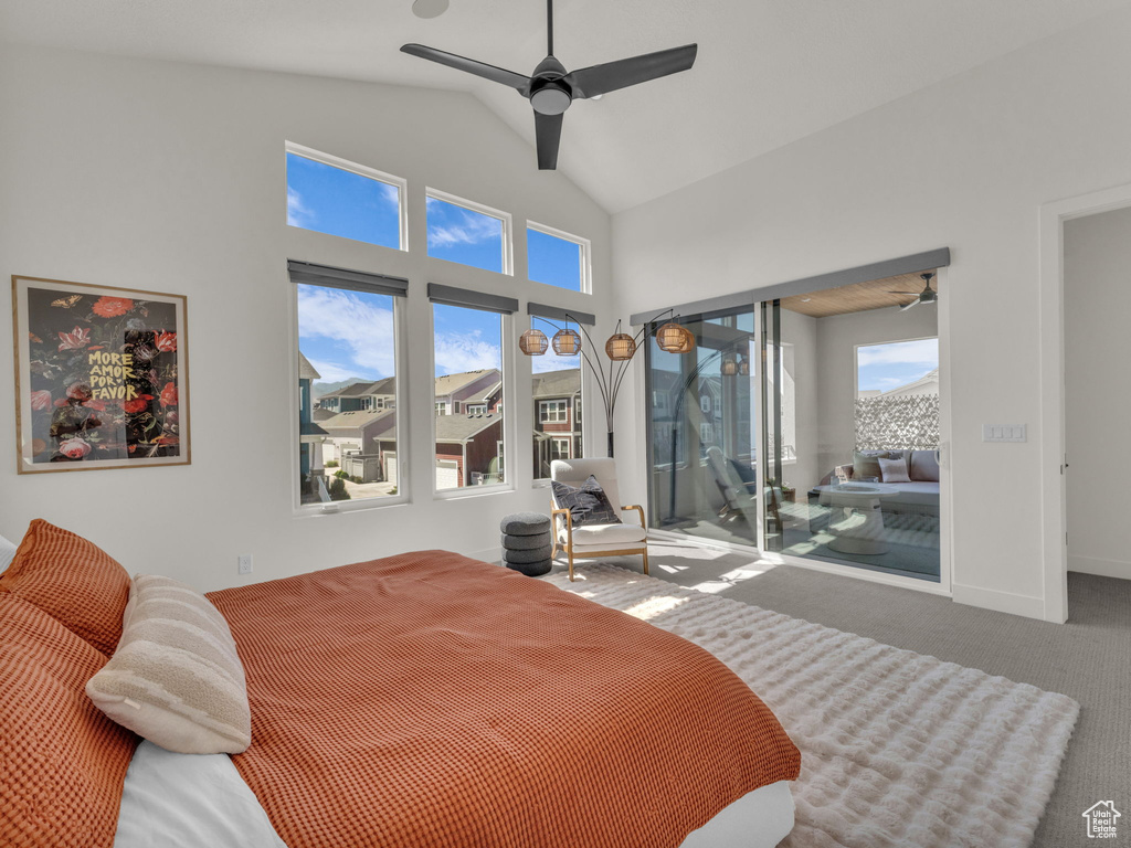 Carpeted bedroom featuring access to outside, vaulted ceiling, and a ceiling fan