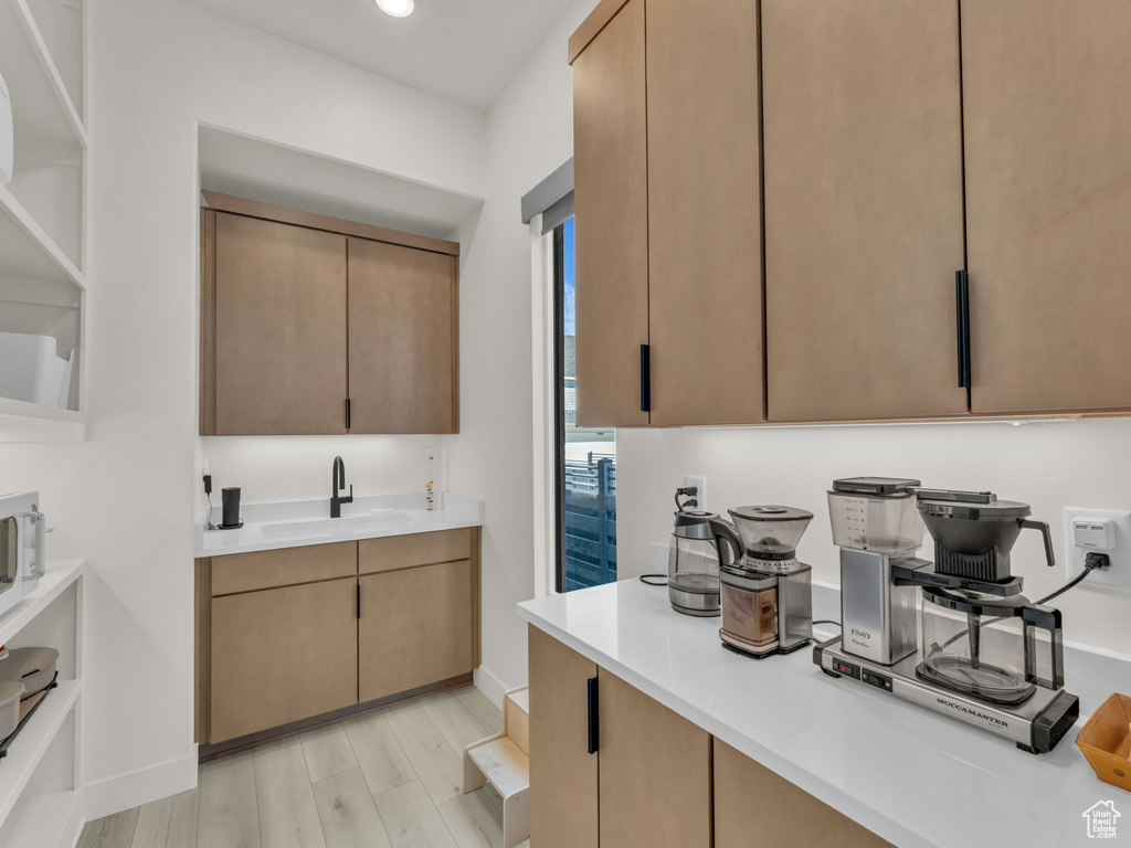 Kitchen with light countertops, light wood finished floors, and recessed lighting