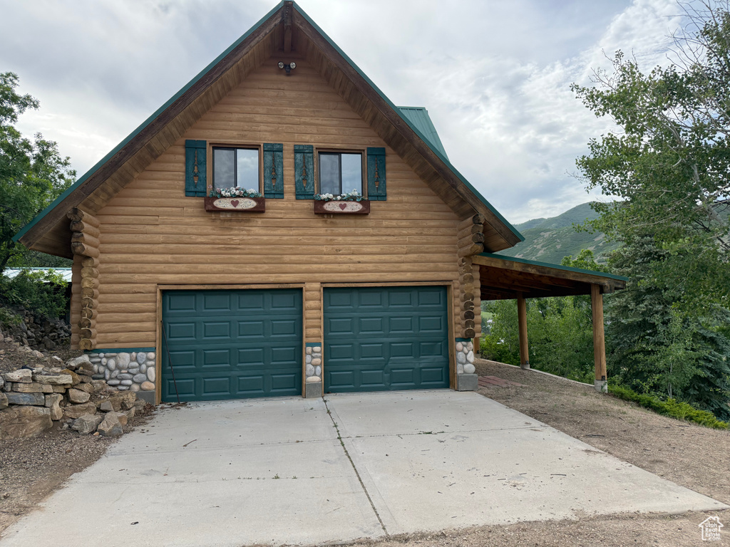 Garage with driveway and a mountain view