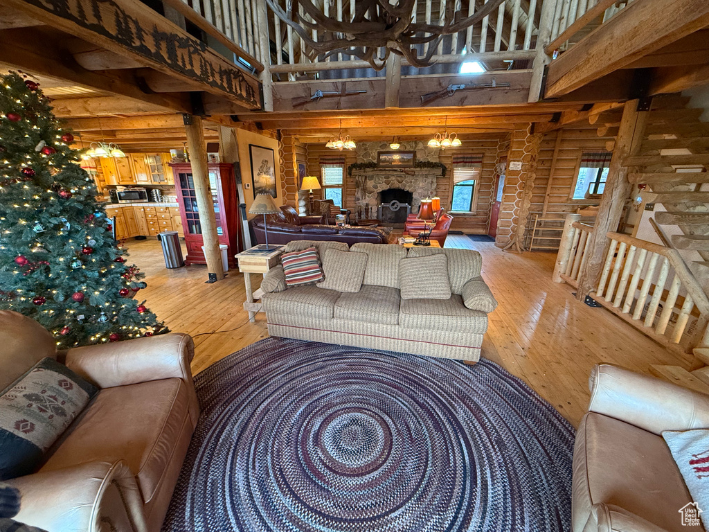 Living area with log walls, light wood-type flooring, and a high ceiling