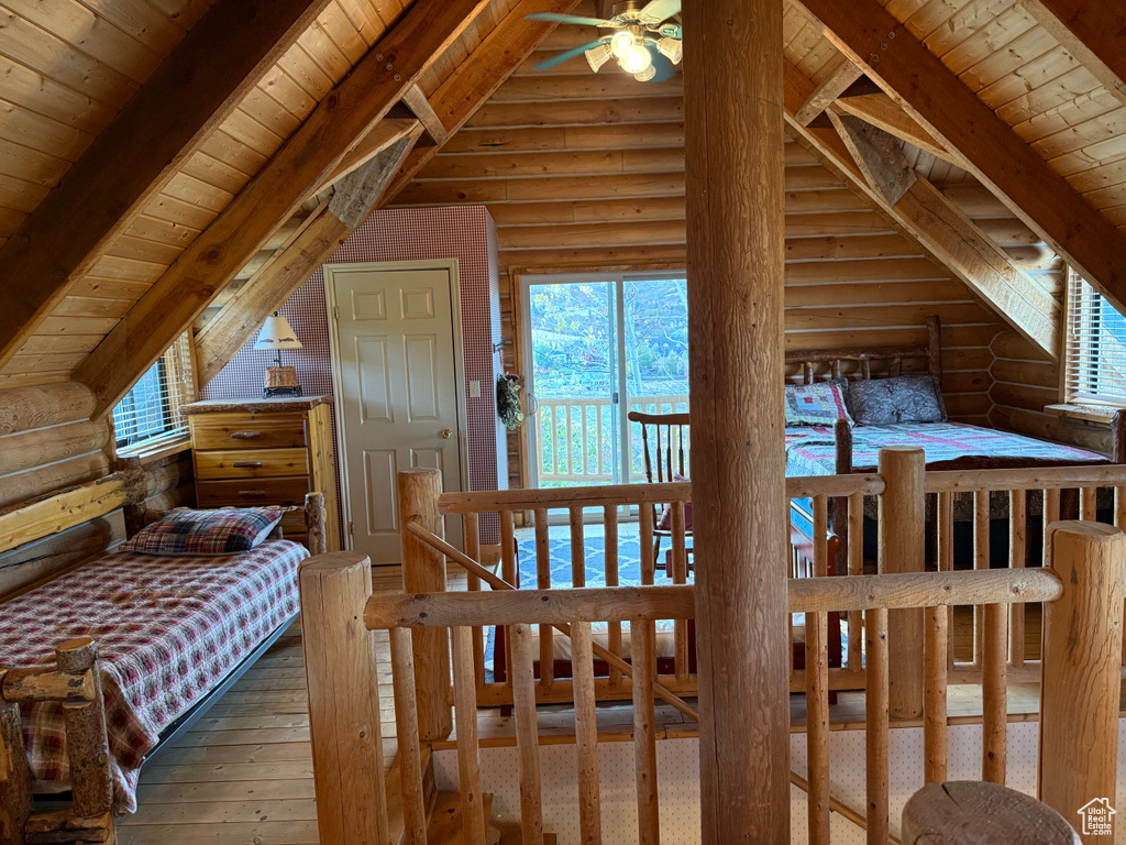 Bedroom featuring rustic walls, wood ceiling, wood-type flooring, and multiple windows