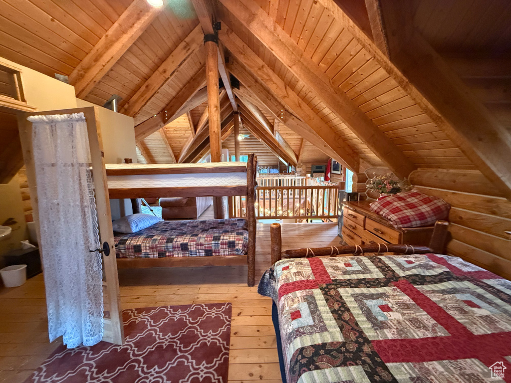 Bedroom featuring wood ceiling, wood-type flooring, and log walls