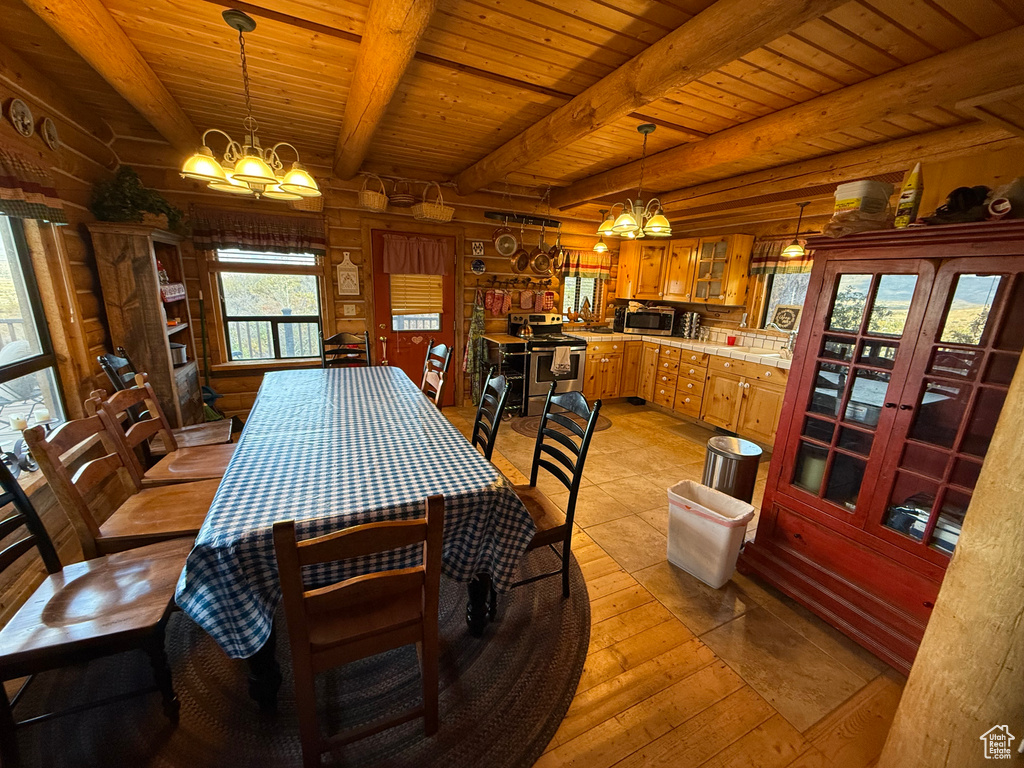 Dining space featuring a chandelier, rustic walls, a wood ceiling with exposed beams, and light wood-style flooring