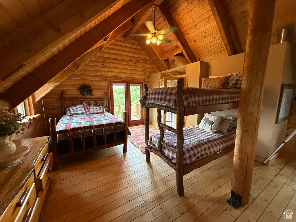 Bedroom featuring access to outside, hardwood / wood-style floors, wooden ceiling, and log walls