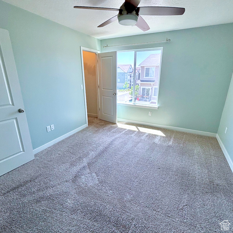 Unfurnished bedroom with carpet floors, a ceiling fan, and a textured ceiling