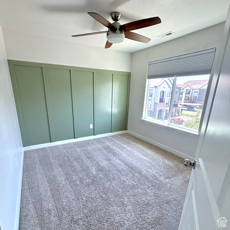 Unfurnished bedroom featuring carpet, a closet, and a ceiling fan