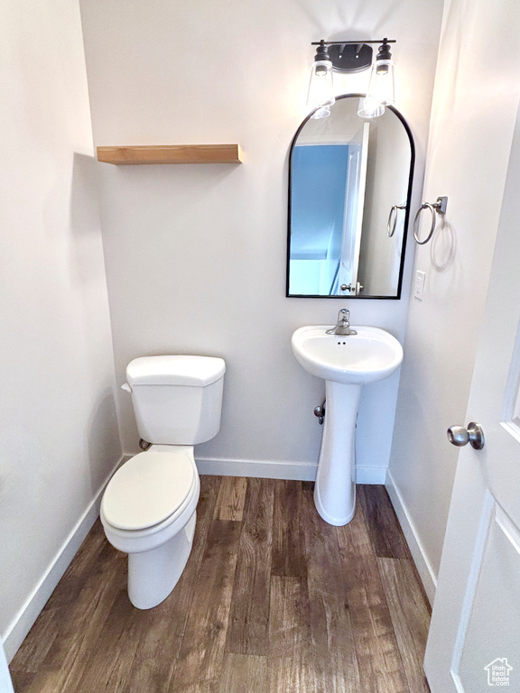Bathroom featuring wood finished floors and toilet