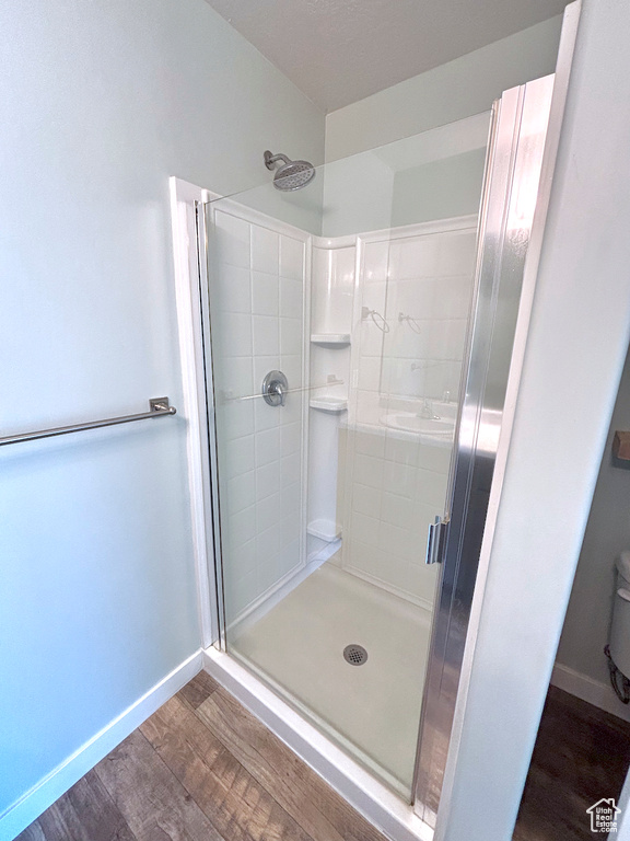 Full bathroom with wood finished floors and a shower stall