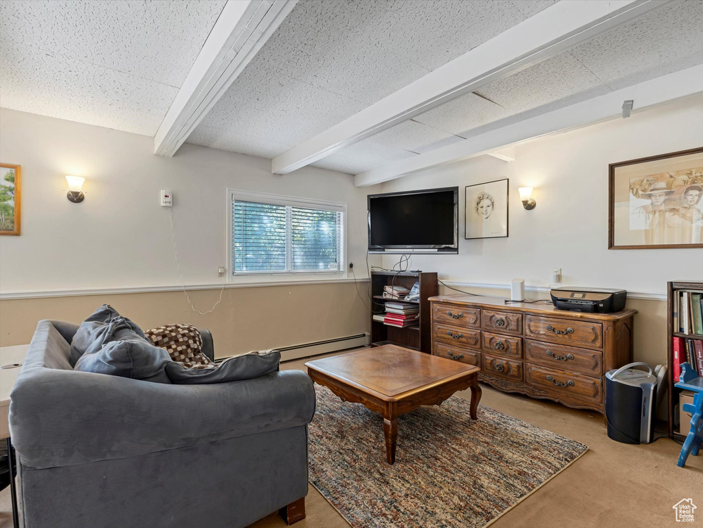 Carpeted living area with beamed ceiling and a baseboard heating unit