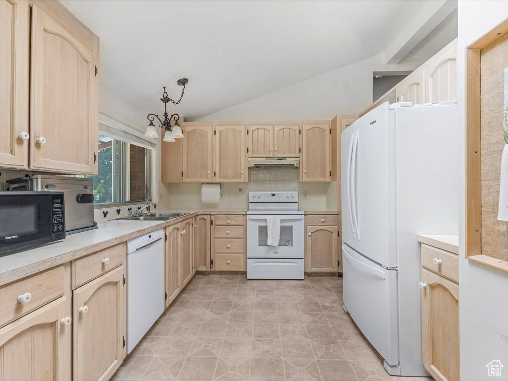 Kitchen featuring white appliances, light brown cabinets, under cabinet range hood, and lofted ceiling