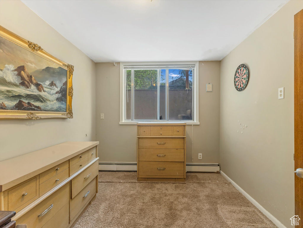 Bedroom with a baseboard radiator and light carpet