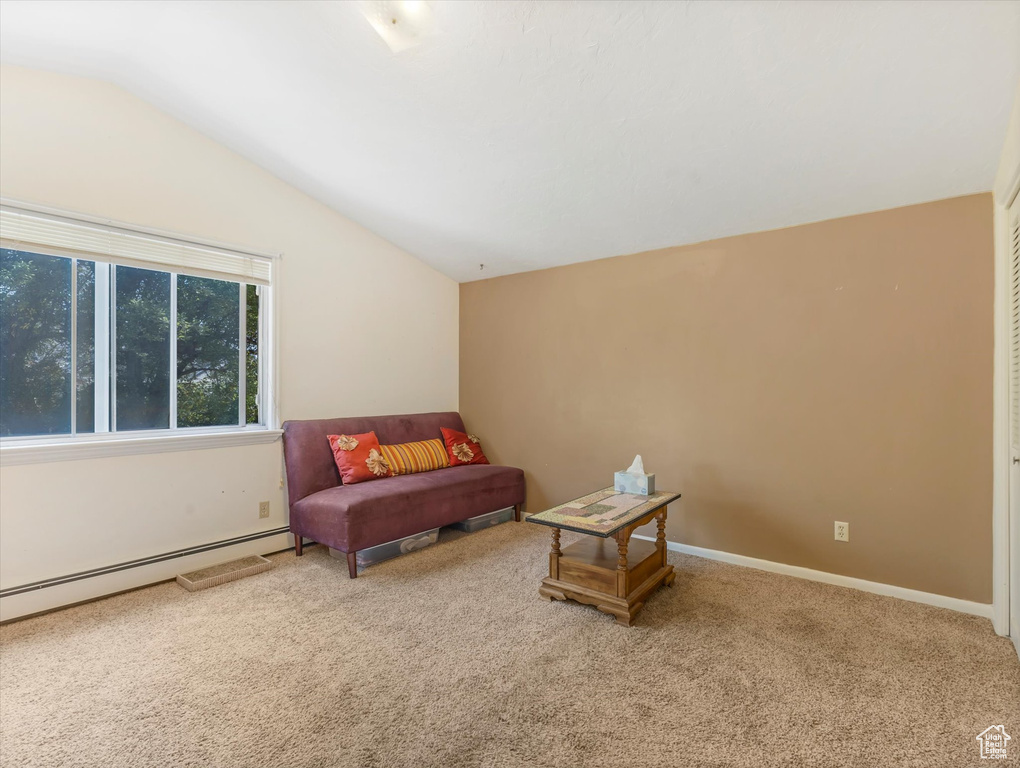 Sitting room featuring vaulted ceiling, carpet flooring, and a baseboard heating unit