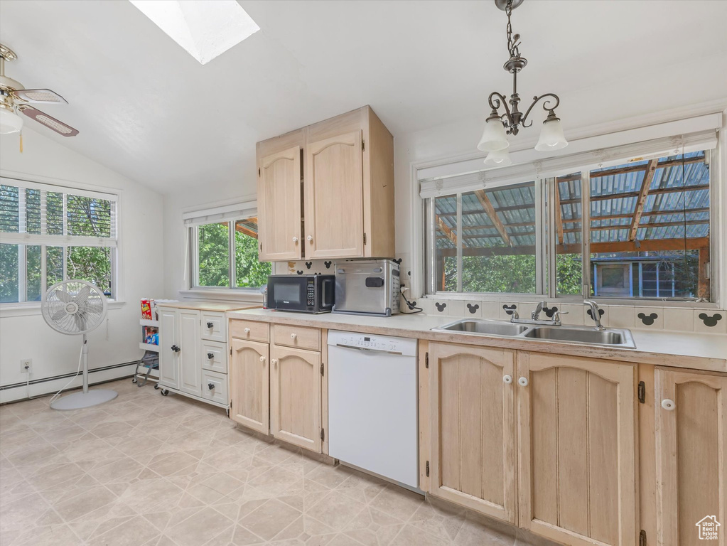 Kitchen with white dishwasher, black microwave, light brown cabinetry, a skylight, and light countertops