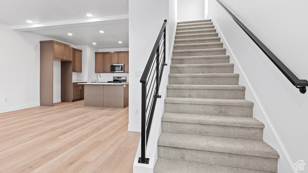 Stairway with recessed lighting and wood finished floors