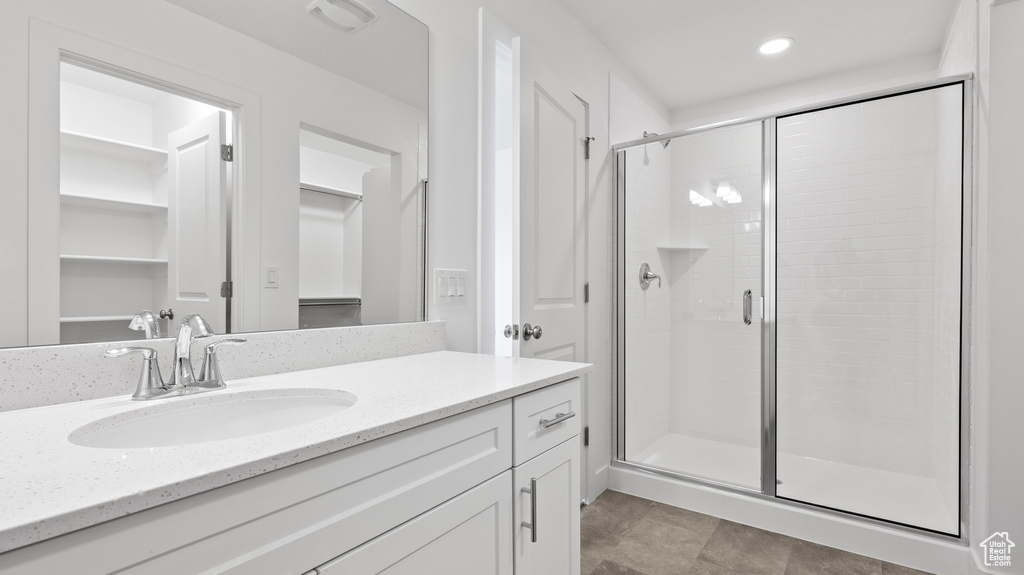 Bathroom with vanity, a shower stall, and recessed lighting