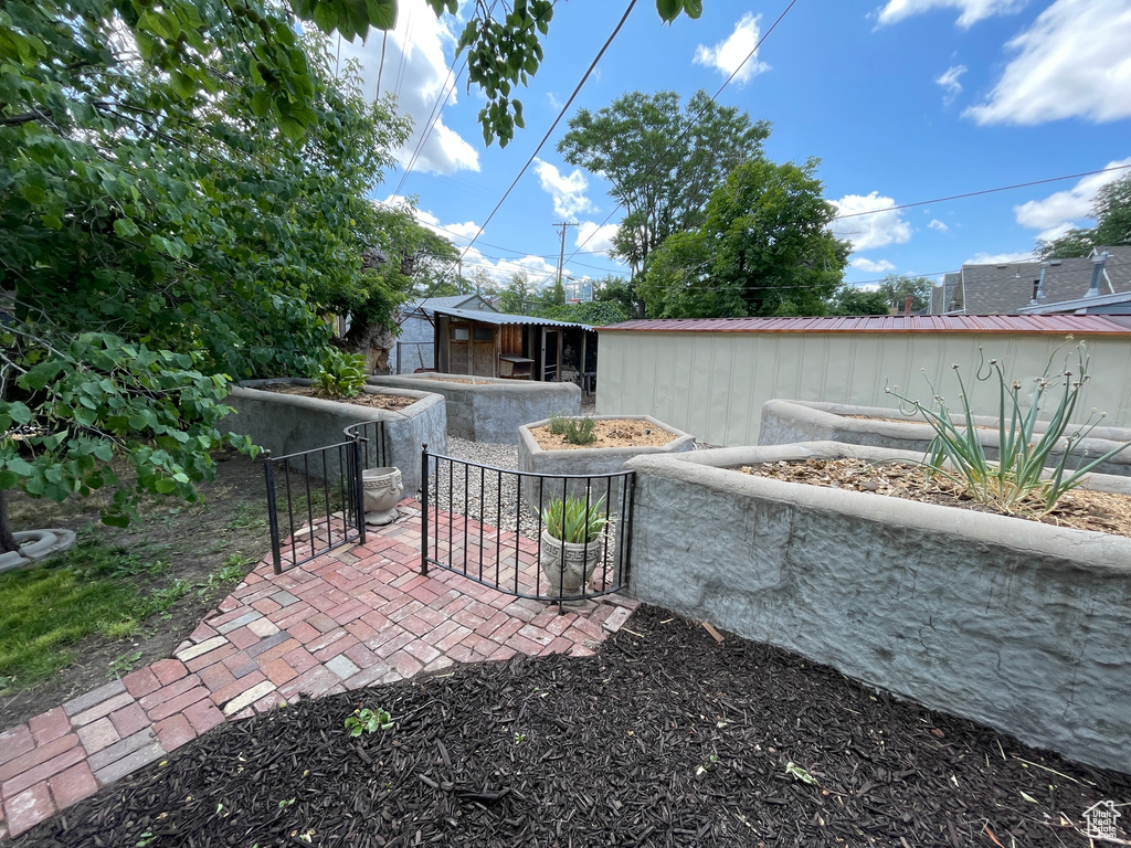 View of patio with a gate and an outdoor structure