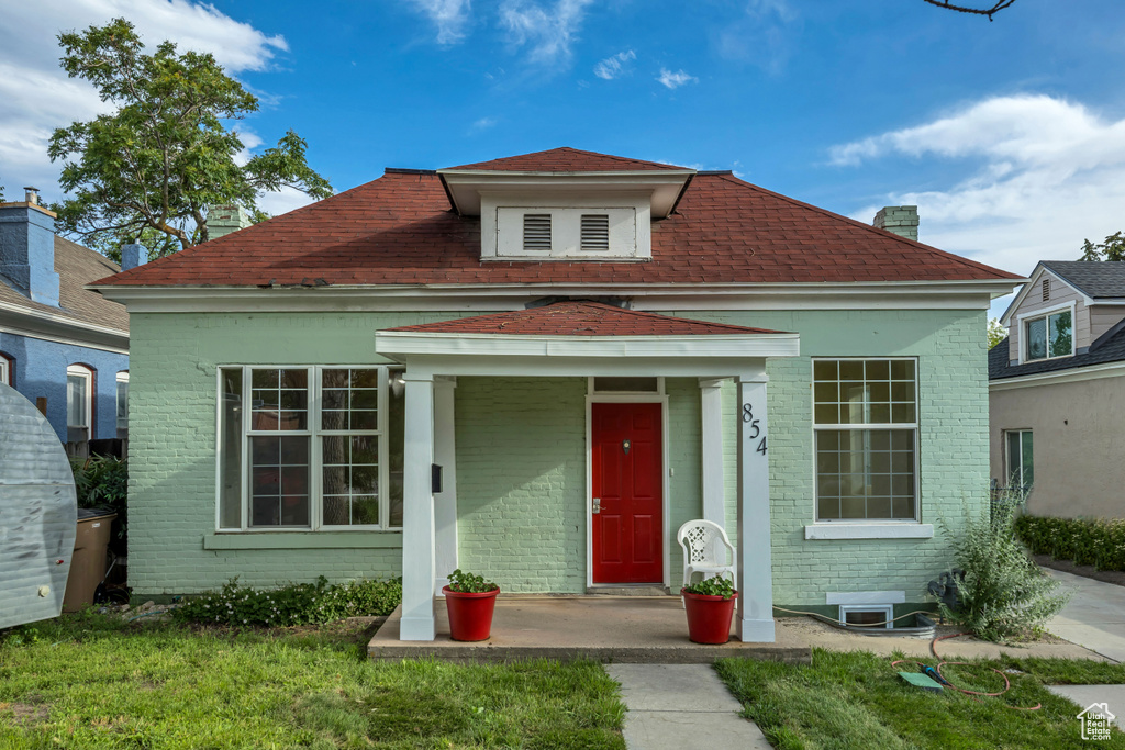 View of front of property with brick siding and a shingled roof