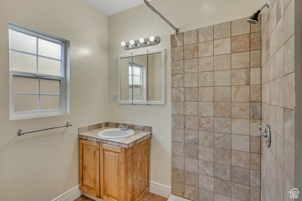 Full bathroom with vanity and tiled shower