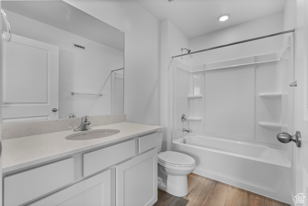 Bathroom with vanity, shower / tub combination, and wood finished floors