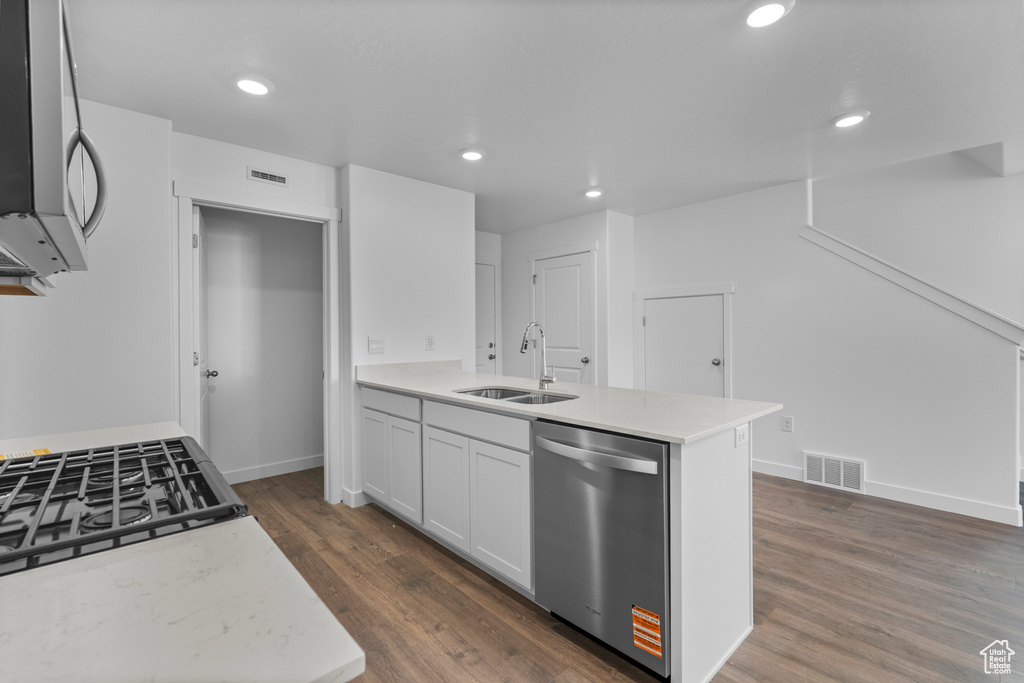 Kitchen with stainless steel appliances, dark wood-style flooring, a peninsula, light stone counters, and recessed lighting