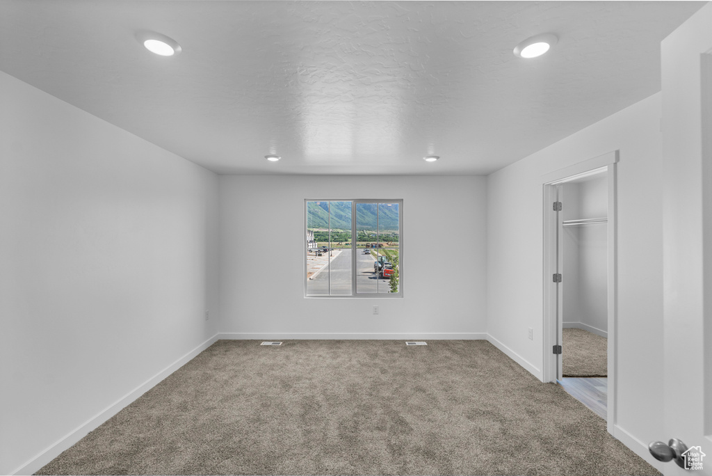Unfurnished bedroom with carpet flooring, recessed lighting, and a walk in closet
