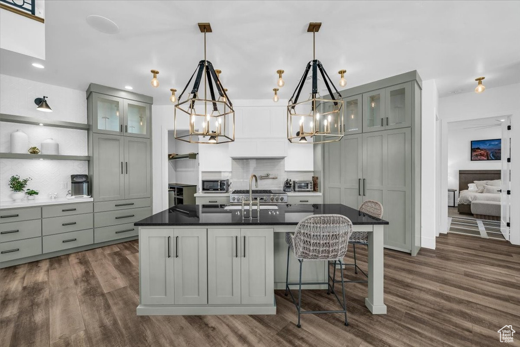 Kitchen featuring a chandelier, open shelves, dark countertops, backsplash, and dark wood-style floors