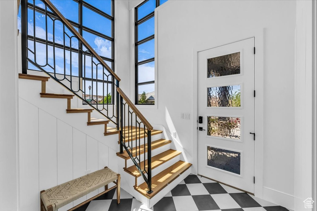 Foyer featuring tile patterned floors, stairs, and a towering ceiling