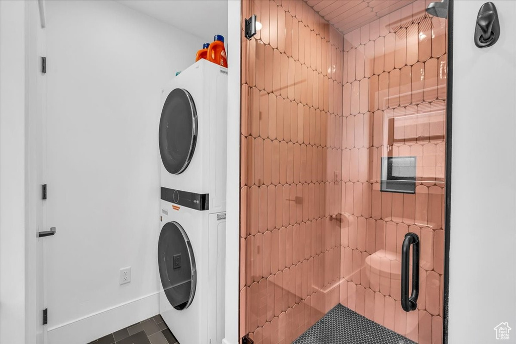 Laundry room with stacked washer / dryer and tile patterned flooring