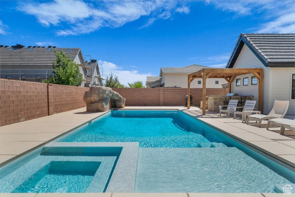 View of pool featuring a fenced backyard, an outdoor kitchen, and a patio area