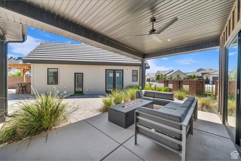 View of patio with an outdoor living space with a fire pit, french doors, and ceiling fan