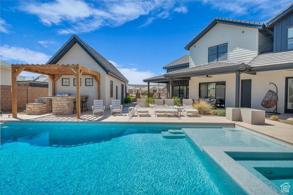 View of pool with a patio and a pool with connected hot tub