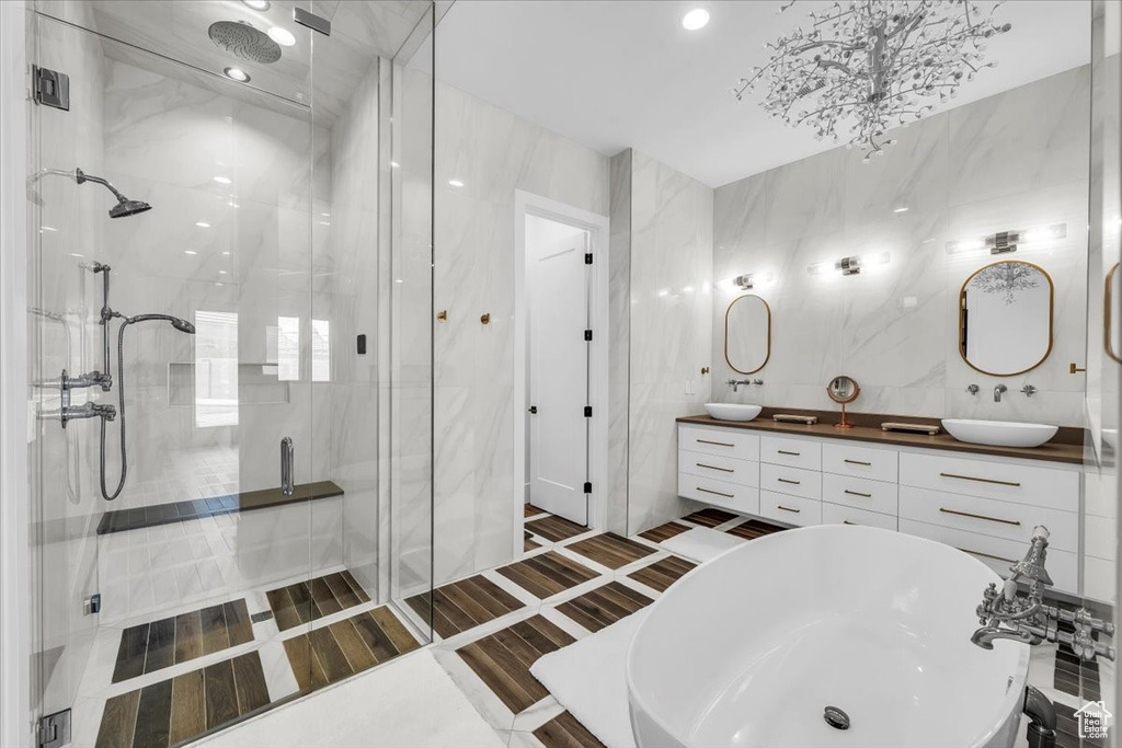 Bathroom with a stall shower, double vanity, a soaking tub, and recessed lighting