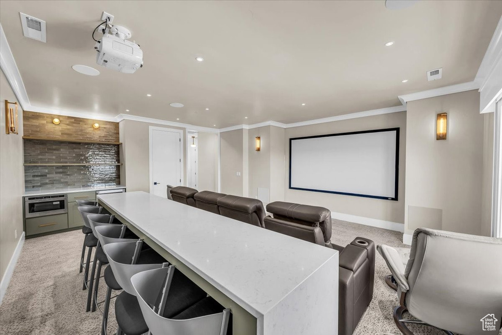 Cinema with recessed lighting, ornamental molding, and light colored carpet