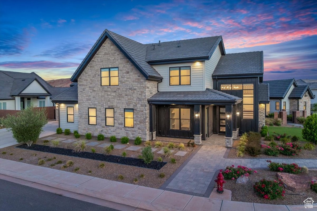 Modern home featuring stone siding and a porch