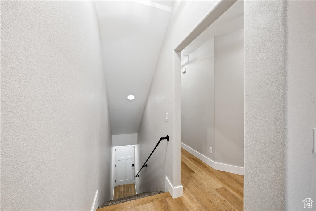 Stairs featuring wood finished floors and recessed lighting