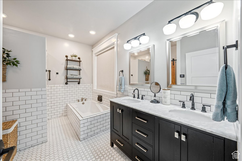 Bathroom with double vanity, a garden tub, tile patterned floors, and recessed lighting
