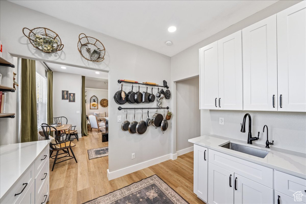 Kitchen featuring light wood-type flooring, white cabinetry, and recessed lighting