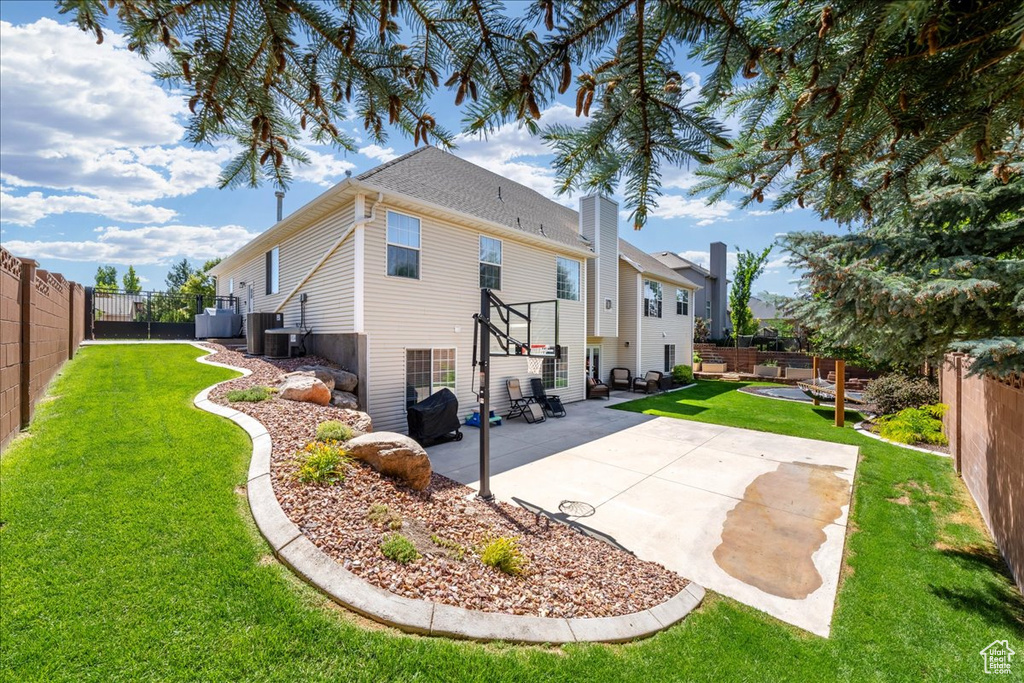 Back of house featuring a fenced backyard, a patio, and a chimney