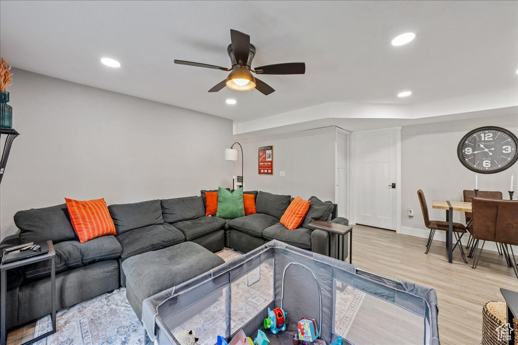 Living area with ceiling fan, light wood finished floors, and recessed lighting