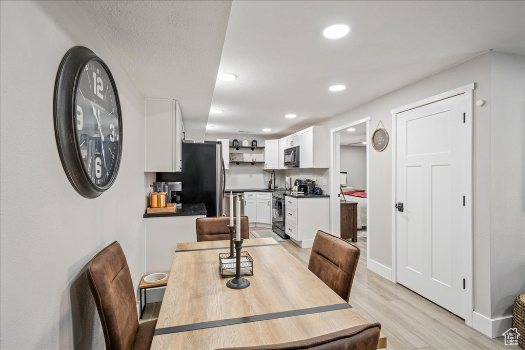 Dining room with light wood finished floors and recessed lighting