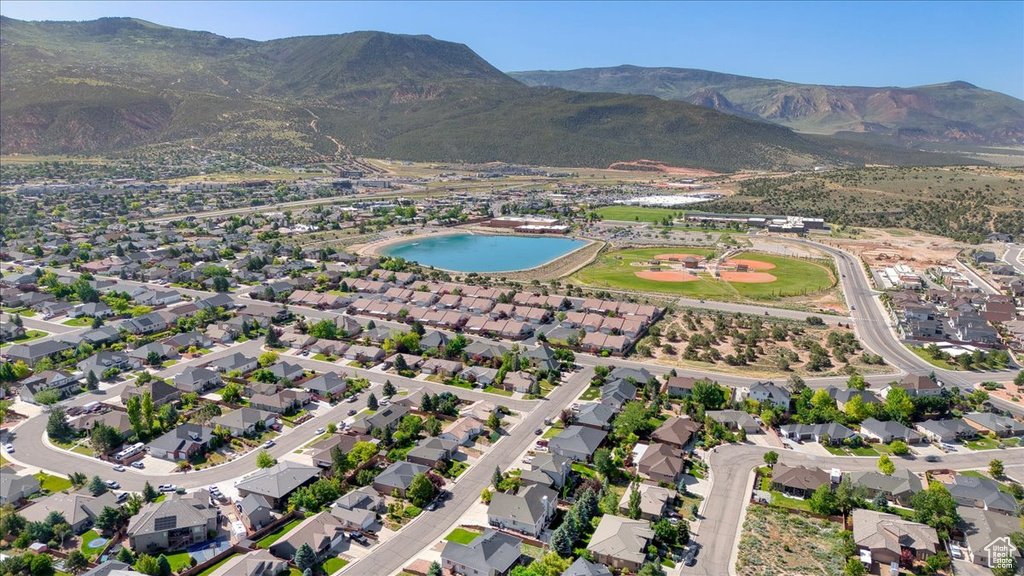 Aerial overview of property\'s location featuring nearby suburban area and a water and mountain view