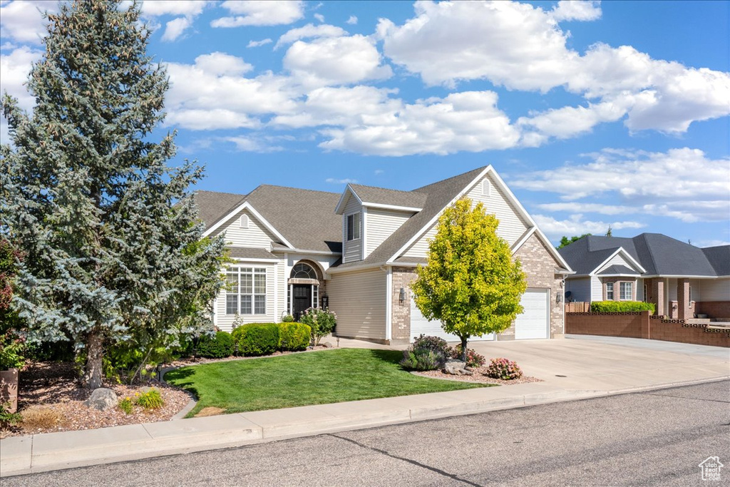 Traditional home featuring concrete driveway, a garage, and brick siding