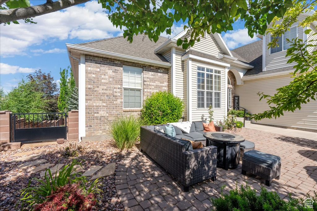 View of patio / terrace featuring an outdoor living space with a fire pit and a gate