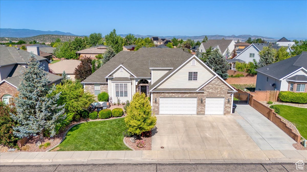 Traditional home featuring brick siding, a residential view, driveway, and a mountain view